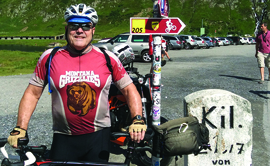 Earnie Williamson ’73 dons his Griz cycling jersey atop Oberalppass in Switzerland near the source of the Rhine River. 