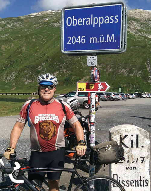 Earnie Williamson ’73 dons his Griz cycling jersey atop Oberalppass in Switzerland near the source of the Rhine River. 