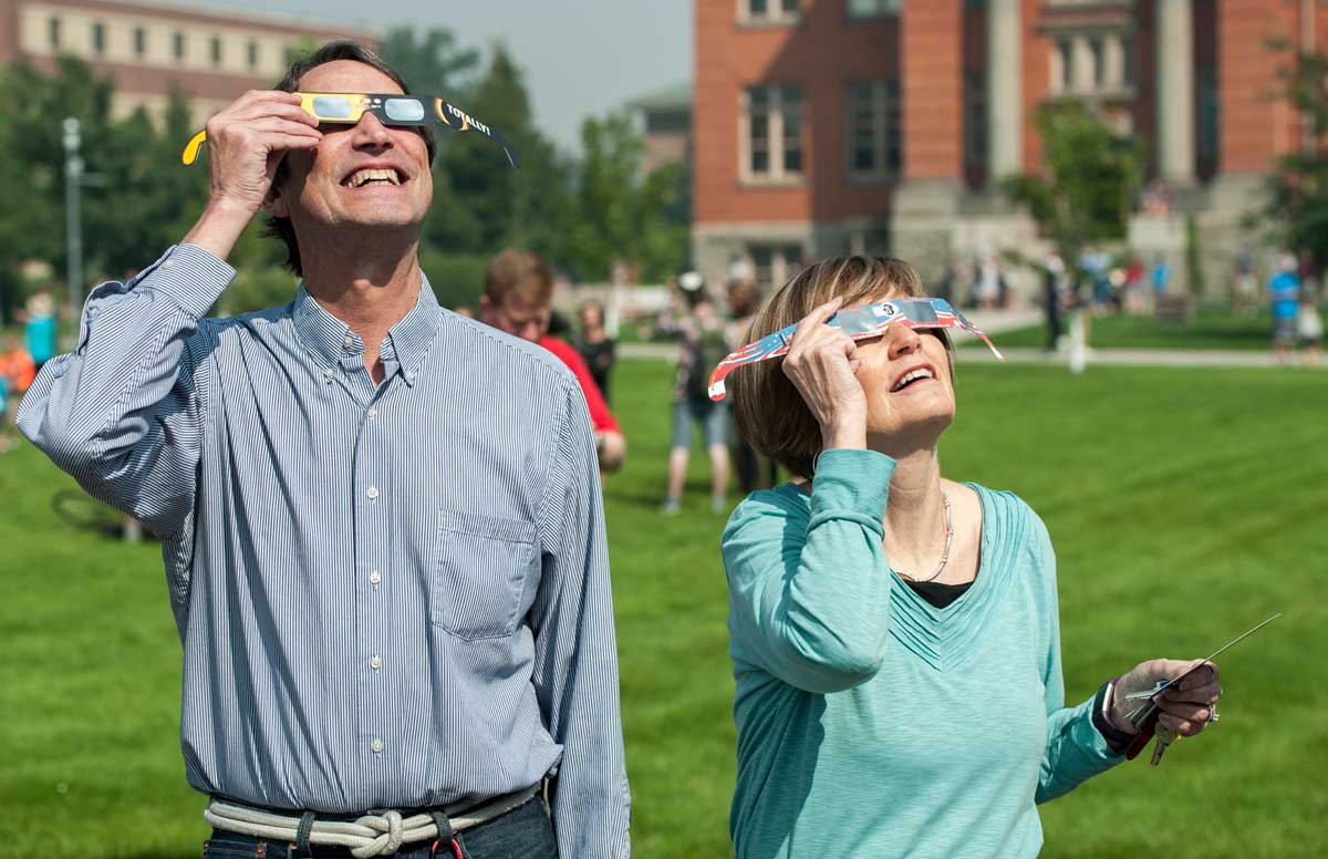 President Sheila Stearns and anthropology instructor Garry Kerr watch the solar eclipse Aug. 21 on the Oval.