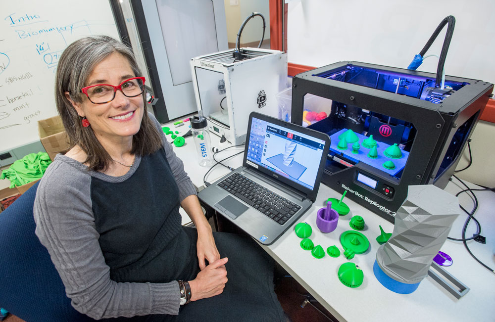 Professor Lisa Blank shows off some of the technology available to students, such as 3-D printers, inside the FabLab at the Phyllis J. Washington Education Center.