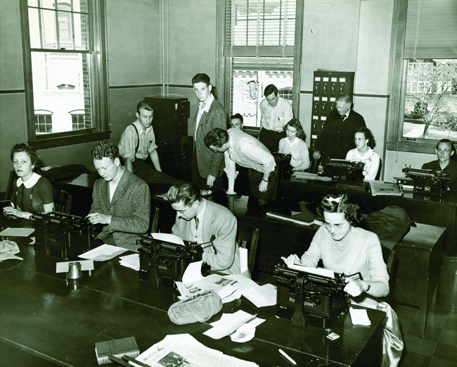 School of Journalism Dean Arthur Stone, back middle, teaches a class in the Old Journalism Building, recently renamed Stone Hall in his honor. (RG 06-6-1 Archives and Special Collections, Mansfield Library, the University of Montana)