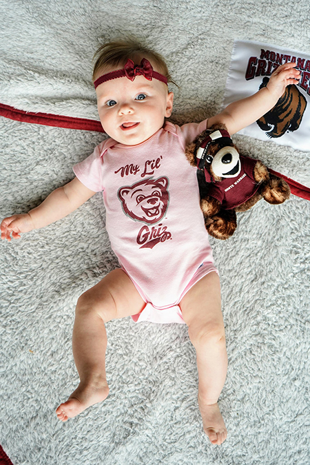A baby girl wearing pink Griz gear 