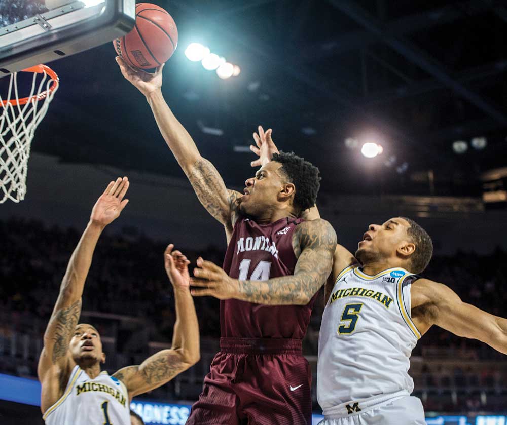 Griz guard Ahmaad Rorie drives to the basket against two Michigan defenders during the NCAA tournament. 