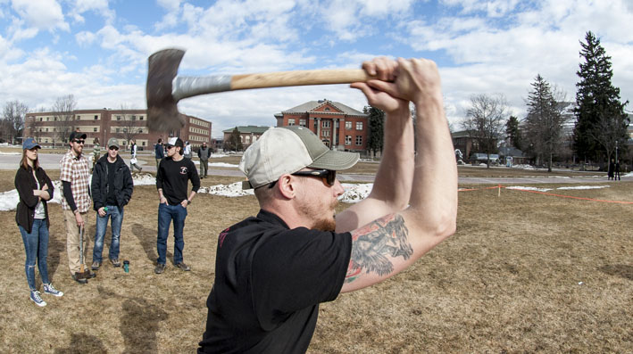A member of the UM Woodsmen Team winds up to throw an ax.