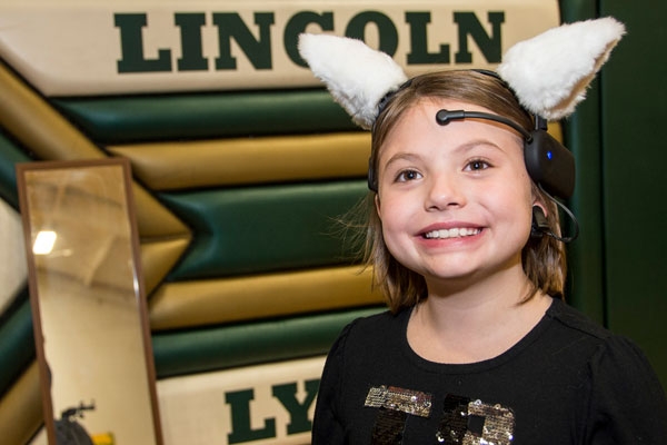 Lincoln school student Nikki Snyder, age ten, tries to make the fuzzy ears wiggle using her brain power.