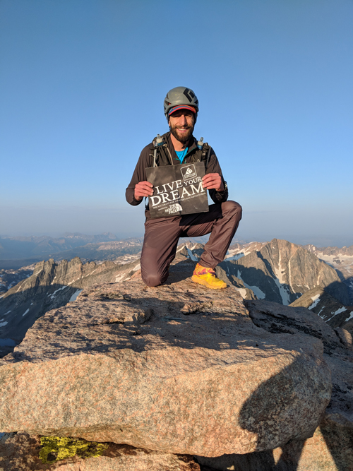 Nate Bender '12 shares a sign atop Granite Peak, Montana's tallest mountain.
