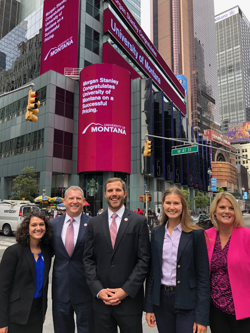 President Seth Bodnar, UM administrators and students pose for a photo on Wall Steet in New York